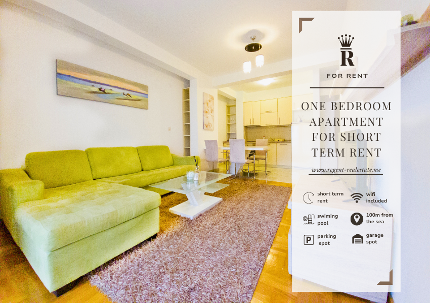 Dnevna soba u jednosobnom apartmanu Djenovici, zelena sofa, stakleni sto, slike, trpezarija i kuhinja u pozadini. Opis nekretnine i simbol Regent real estate
