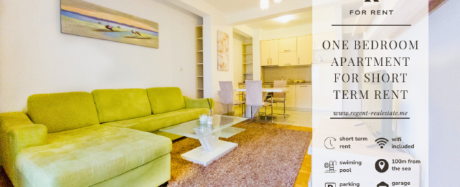 Dnevna soba u jednosobnom apartmanu Djenovici, zelena sofa, stakleni sto, slike, trpezarija i kuhinja u pozadini. Opis nekretnine i simbol Regent real estate